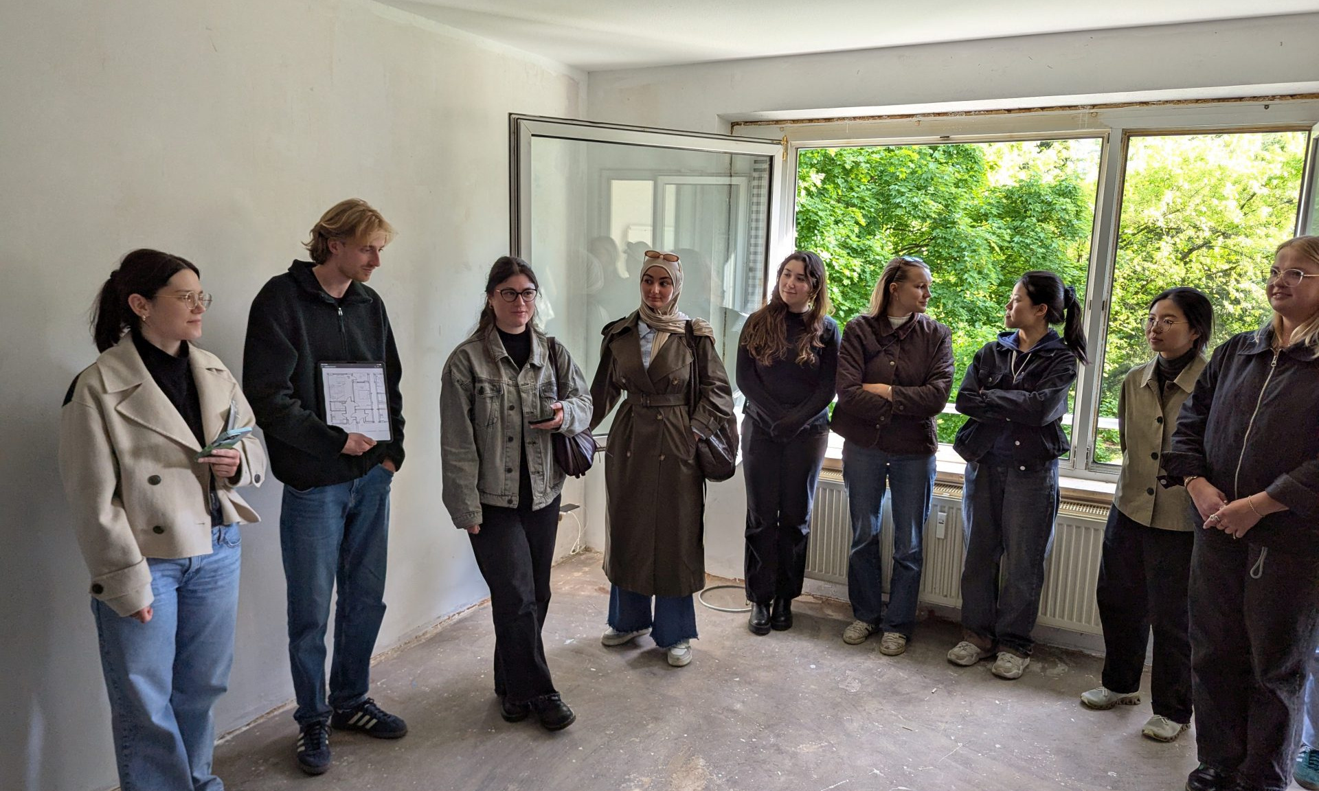 Eine Gruppe von Studierenden in einer leer stehenden Wohnung.