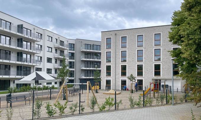 Spielplatz im Vordergrund, Wohnungen des Grimmbogen im Hintergrund