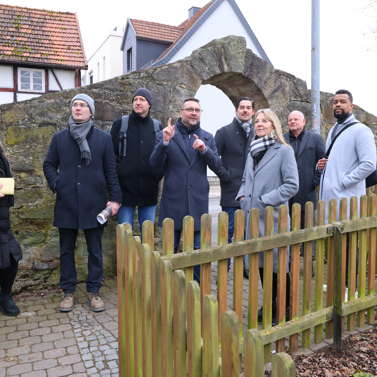 Eine Gruppe von acht Menschen im Freien, vor einer alten Steinmauer, u.a. Torben Busse, Bürgermeister von Hofgeismar, Karin Jasch vom Hessischen Wirtschaftsministerium sowie Ulrich Türk und Marvin Coker von der ProjektStadt.