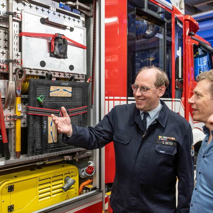 Im Anschluss an die offizielle Übergabe erläuterte Stadtbrandinspektor Gerhard Bayer wichtigsten Ausrüstungsgegenstände der Feuerwehr beim Brandeinsatz. Foto: NHW/Strohfeldt