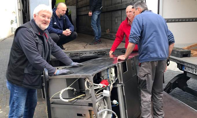 Vier Männer verladen Klinik-Equipment in einen Lkw