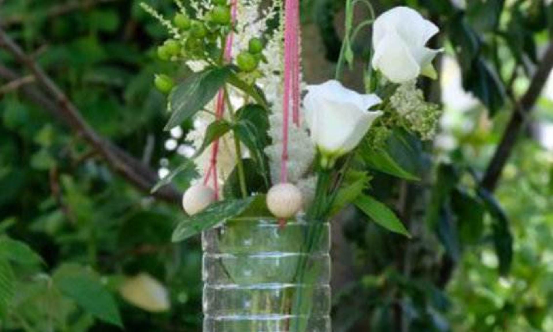 Hängende Blumenvase aus PET-Flaschen mit Blumen.