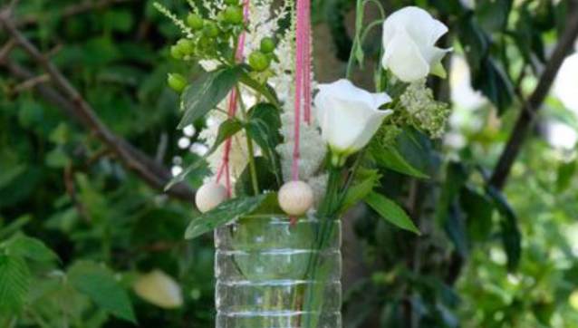 Hängende Blumenvase aus PET-Flaschen mit Blumen.