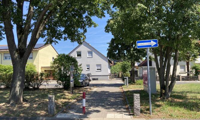 Grünstreifen in einem Wohngebiet mit Durchgang und Einbahnstraßenschild