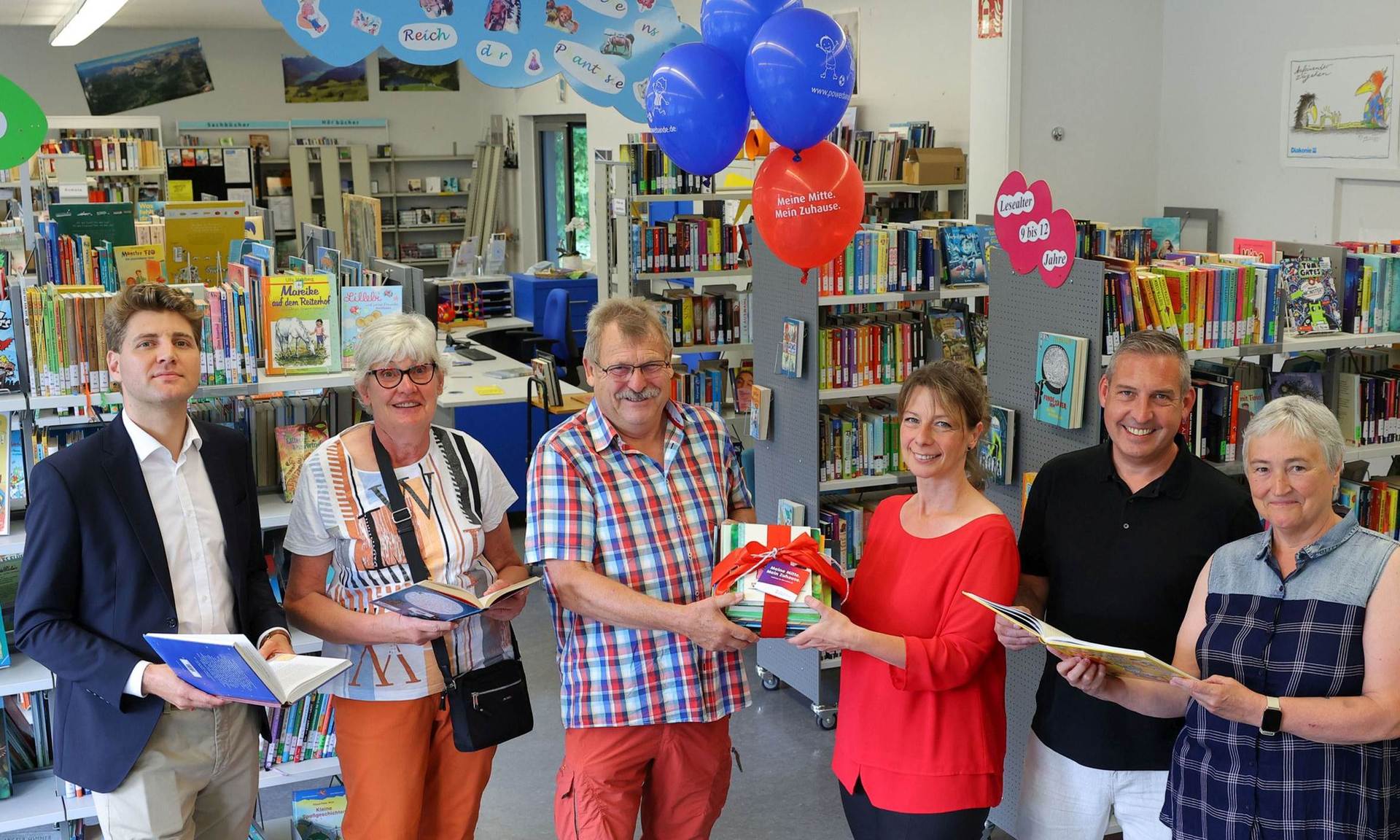 (v. l.) Alexander Hauschild (Projektleiter Sozialmanagement, NHW), Heidrun Trapp (Vorständin Stadtteilbücherei Fasanenhof e. V.), Wolfgang Trapp (Vorstand Stadtteilbücherei Fasanenhof e. V.), Jennifer Linke (Projektleiterin Sozialmanagement, NHW), Sascha Holstein (Leiter Regionalcenter Kassel, NHW), Elke Ebert (Vorständin Stadtteilbücherei Fasanenhof e. V.) übergeben die Bücherspende. 