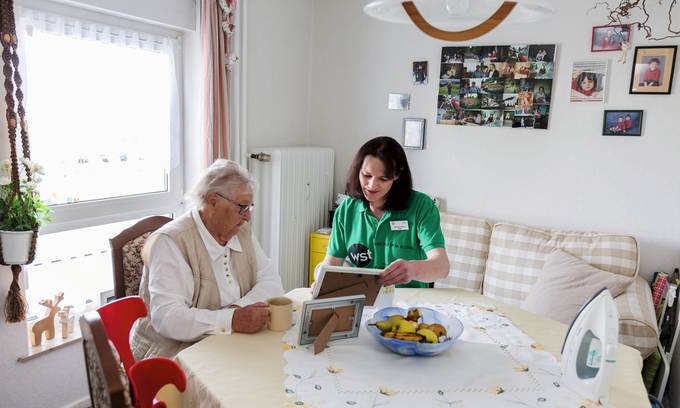 Zwei Menschen an Tisch in Wohnung