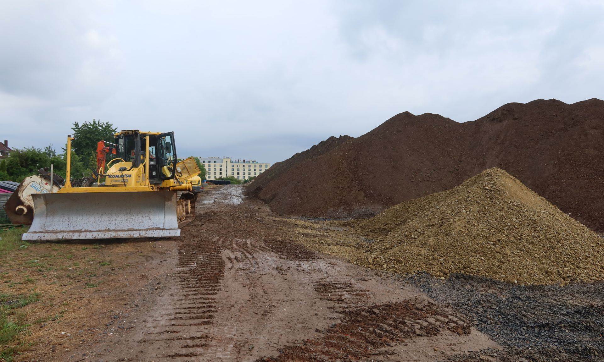 Bagger und ganz viel Sand- und Erdhaufen