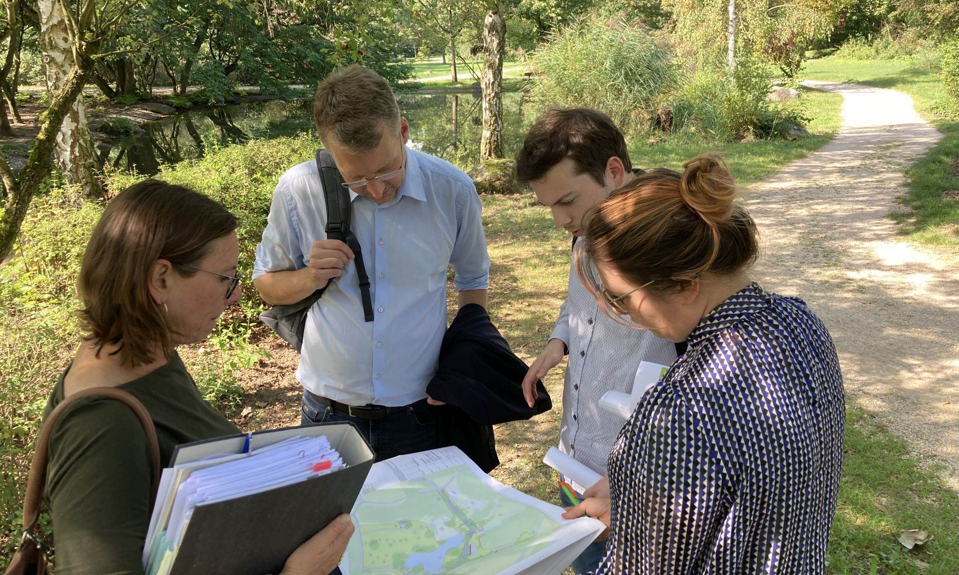 Vier Personen im Grünen mit Unterlagen: Heiko Körner und Benedikt Sauer vom Land Hessen mit Bettina Weise (Stadt Kelsterbach) und Malaika Rahm (ProjektStadt)